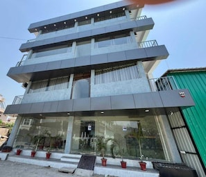 Un edificio de varios pisos con diseño moderno, que cuenta con balcones y ventanas amplias.