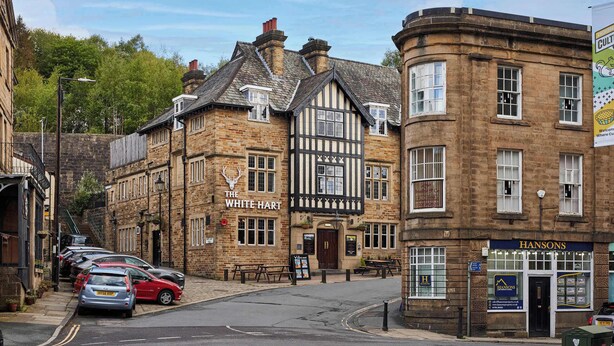 A traditional building with a pub named 'The White Hart' and a property agency named 'Hansons' on the ground floor. - Host & Stay | Lower Cross Lee Cottage (Todmorden)
