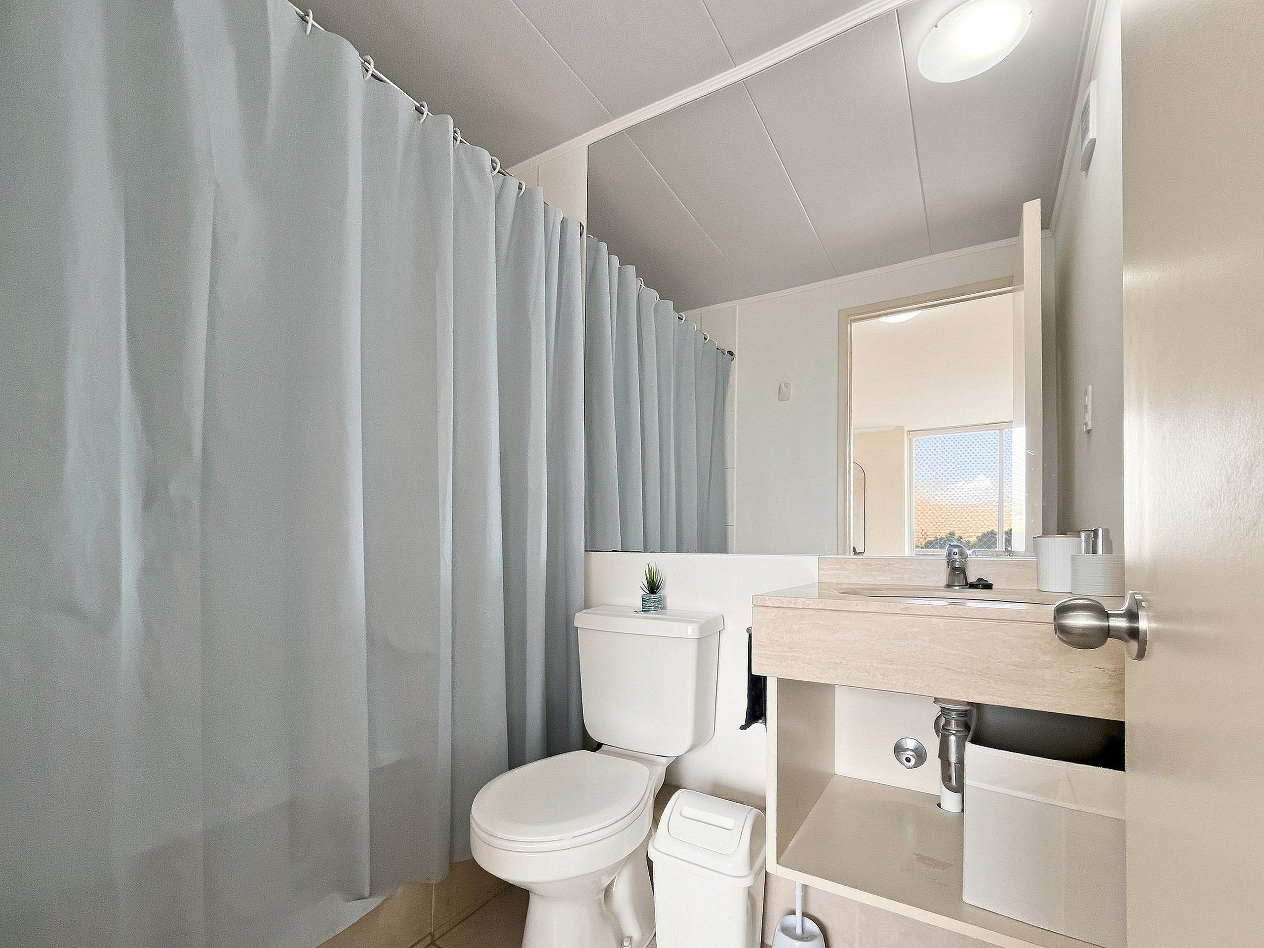 Ein Badezimmer mit Toilette, Waschbecken und Duschvorhang.