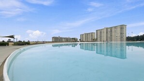 A swimming pool with a clear reflection of buildings in the background. - Oceana Suites Laguna Bahía (Algarrobo)