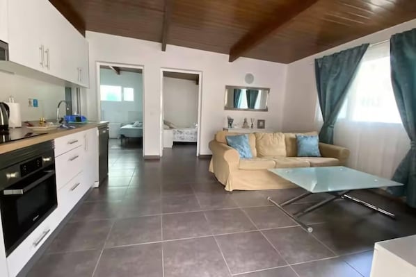 A modern living space with a kitchen, dining area, and a sofa with a coffee table.