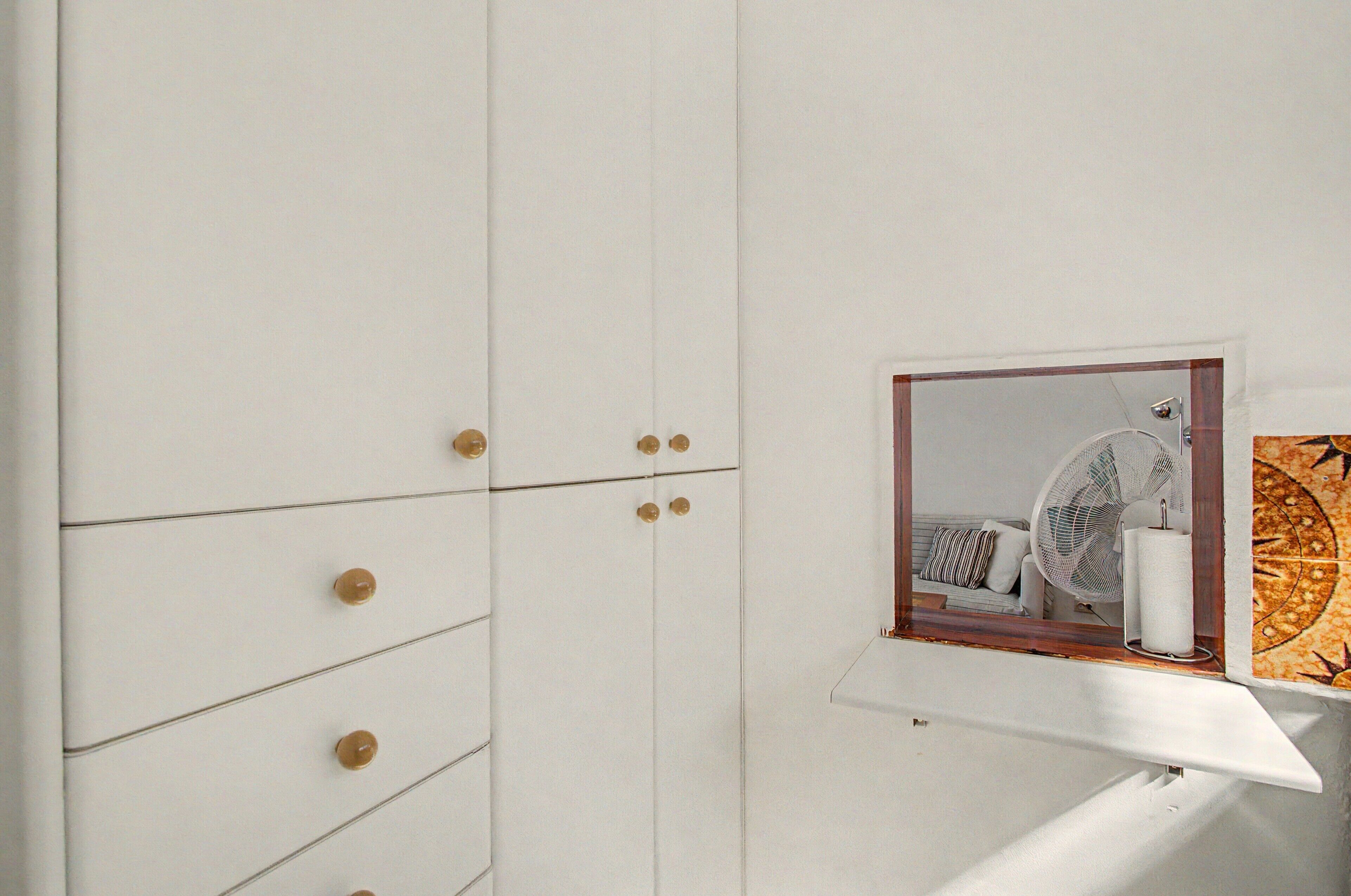 Une salle de bain avec un meuble blanc, un miroir et un porte-serviettes.