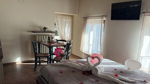Une chambre à coucher avec un lit, un bureau, une chaise et un téléviseur.