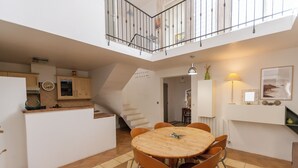 Eine geräumige Küche mit Essbereich, einer Treppe und einem Balkon.
