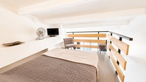 A modern bedroom with a bed, a chair, a TV, and a fan. - Naturiste Cap d'Agde Port Soleil 590 (Cap d'Agde)