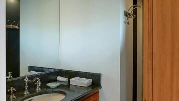 Une salle de bain moderne avec un meuble-lavabo à deux vasques, un grand miroir et une porte en bois.