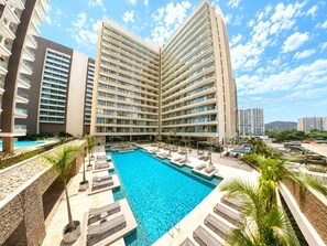 Un hôtel doté d’une grande piscine, de plusieurs étages et d’un design moderne.