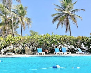 A swimming pool with lounge chairs and palm trees. - Palmas for 2 Breathtaking Oceanview Pool Beach Condado (San Juan)