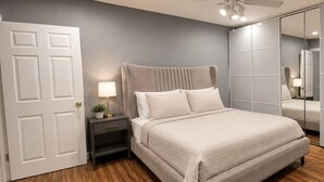 Una camera da letto con un letto, un comodino, una lampada e un armadio.