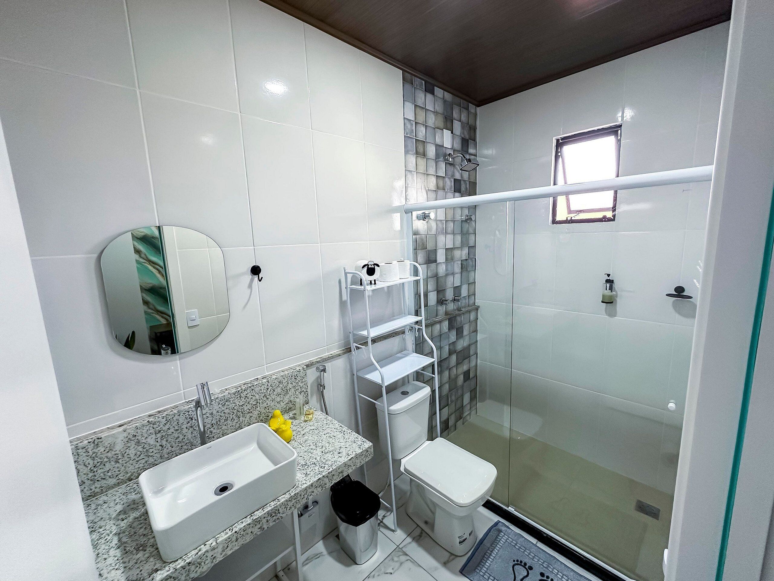 A modern bathroom with a sink, toilet, and glass-enclosed shower.