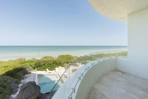 Ein Balkon mit Blick auf den Ozean und den Strand.