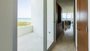 A corridor leading to a balcony with a view of the beach. - Beachfront Paradise with Shared Pool Telchac | Depto A12 (Telchac Puerto)