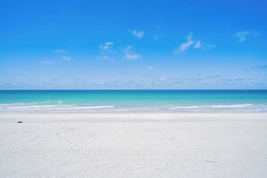 Une plage de sable blanc, sous un ciel bleu azur.