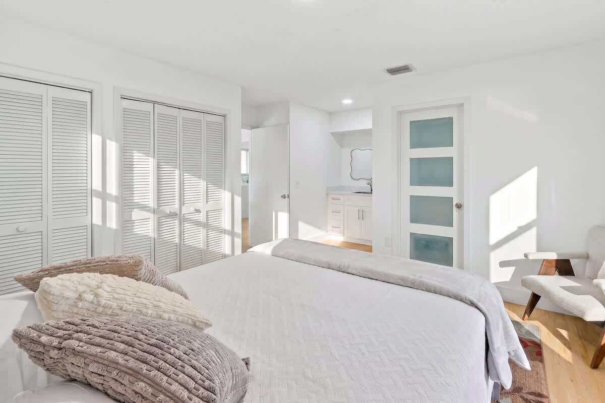 A bedroom with a bed, a chair, and a wardrobe.