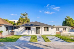 A single-story house with a front porch, a garage, and a well-maintained lawn. - 4BR Oasis Near MIA - Jacuzzi - Games - BBQ (Miami)