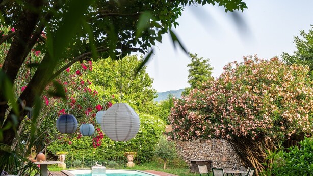 A backyard with a swimming pool, outdoor furniture, and a stone wall. - Gîtes de la Soulondre: Vacation Home with Mountain View, Shared Pool, and Wi-Fi (Lodève)