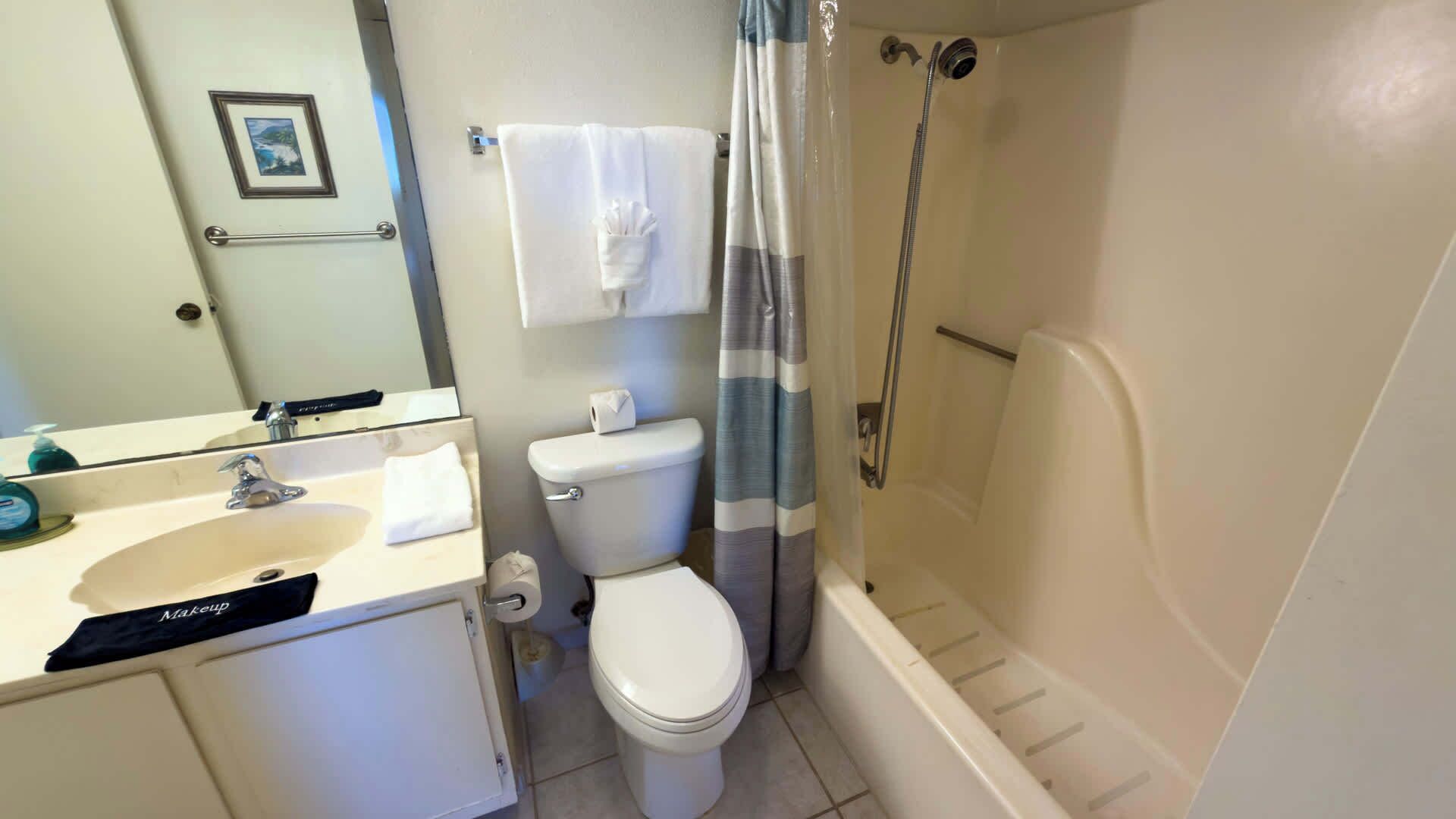 A bathroom with a toilet, sink, and shower.