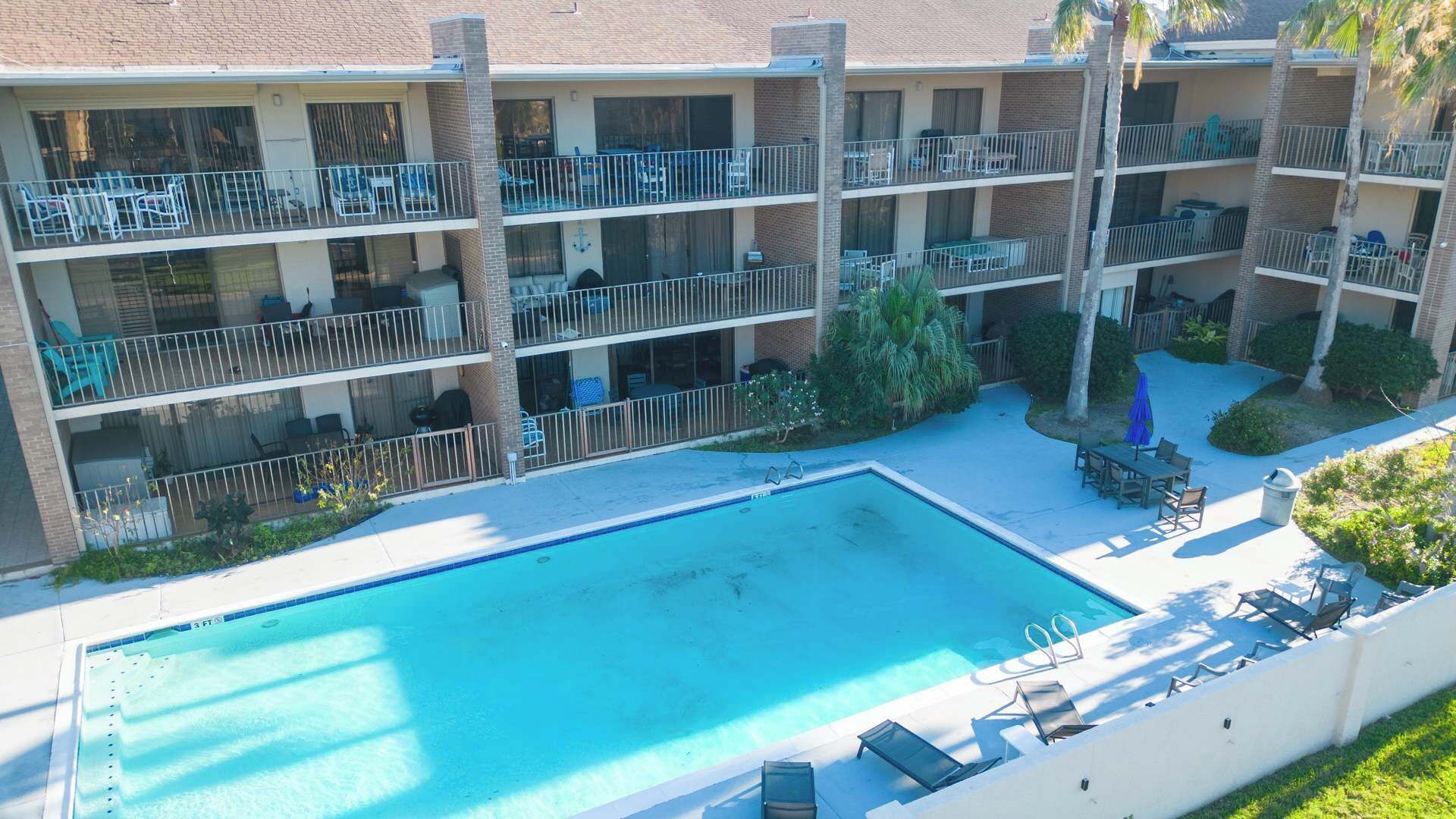 Un hôtel à plusieurs étages doté d’une piscine, d’un espace extérieur aménagé et de balcons.