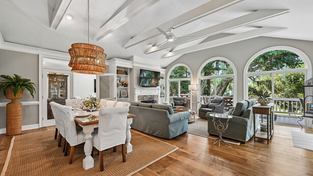 A spacious living area with a dining table, sofas, and a television. - Sea Pines Home w/Views of Harbour Town Golf Course (Hilton Head Island)
