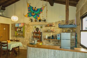 Una cucina rustica con parete in pietra, un bancone in legno e una decorazione a farfalla colorata.