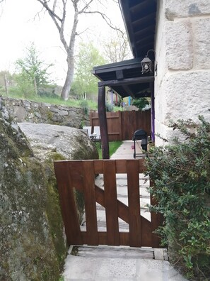 A stone wall, wooden gate, and a pathway leading to a building with a covered porch. - Casa Volvoreta: ideal para familias con piscina cerca de Allariz, Ourense (Acevedo)