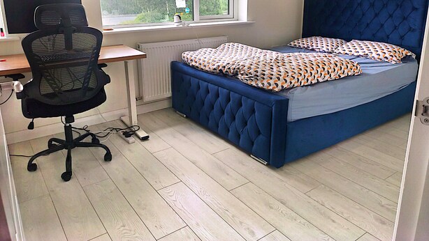 A bedroom with a bed, a desk, a chair, a radiator, and a window. - Room-spacious Double Room With Garden & (Rathnew)