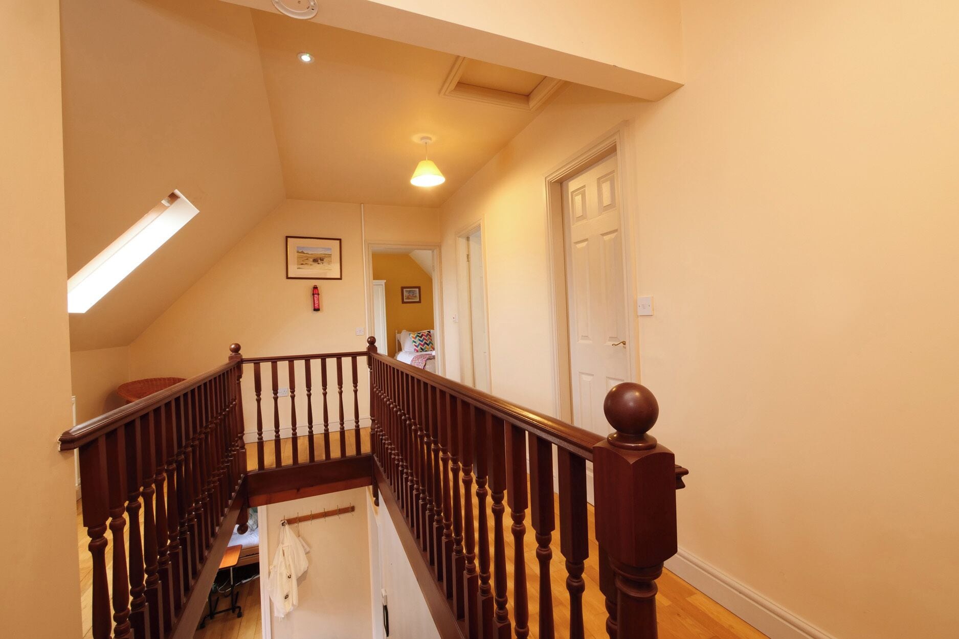 A staircase with wooden balusters, a ceiling light, and a door at the top.