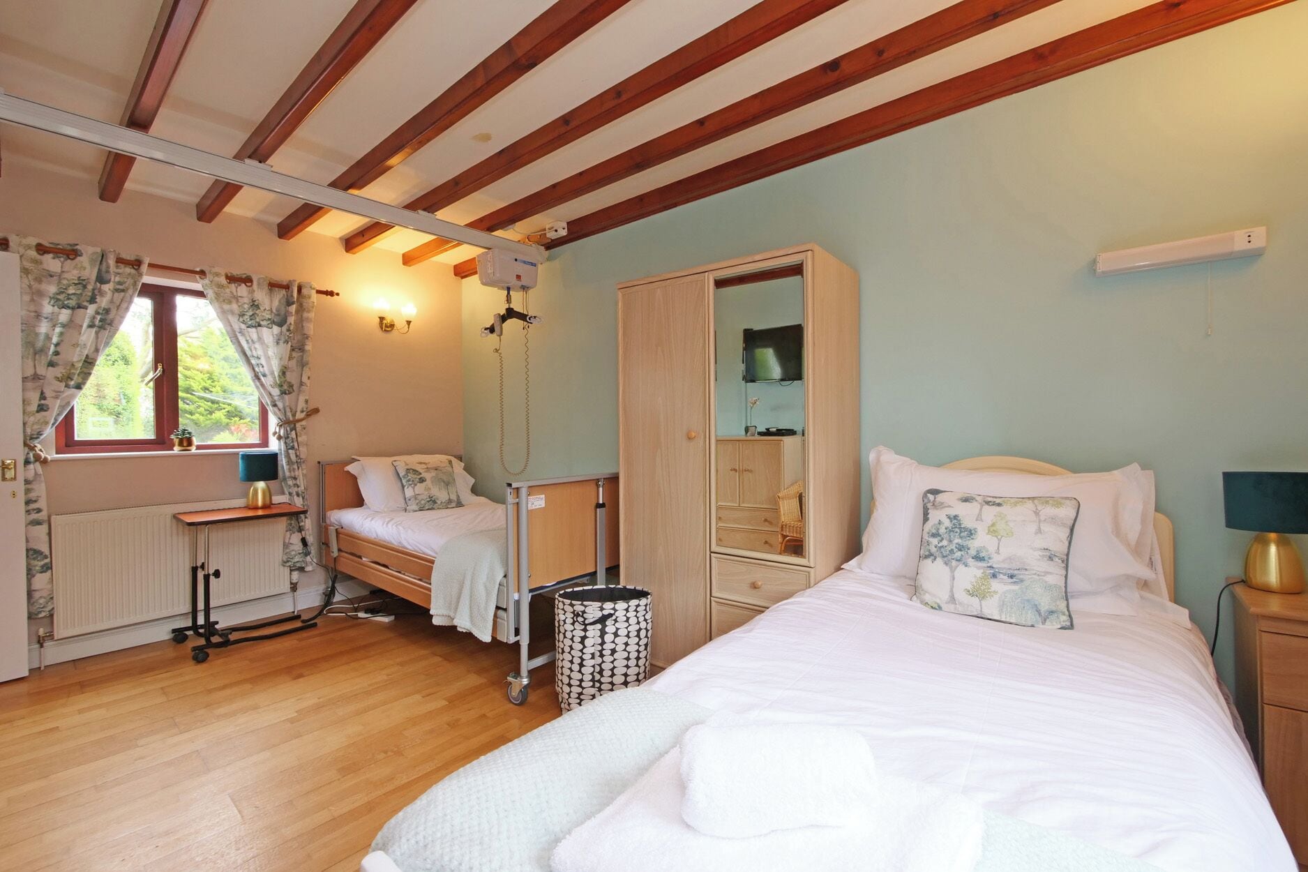 A bedroom with a bed, a dresser, a desk, a chair, and a radiator.