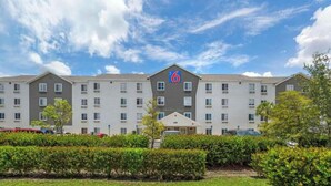 Un hotel de varios pisos con un llamativo letrero con el número '6', que indica la cantidad de habitaciones.