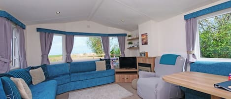 A cozy interior with a sofa, a table, and a TV.