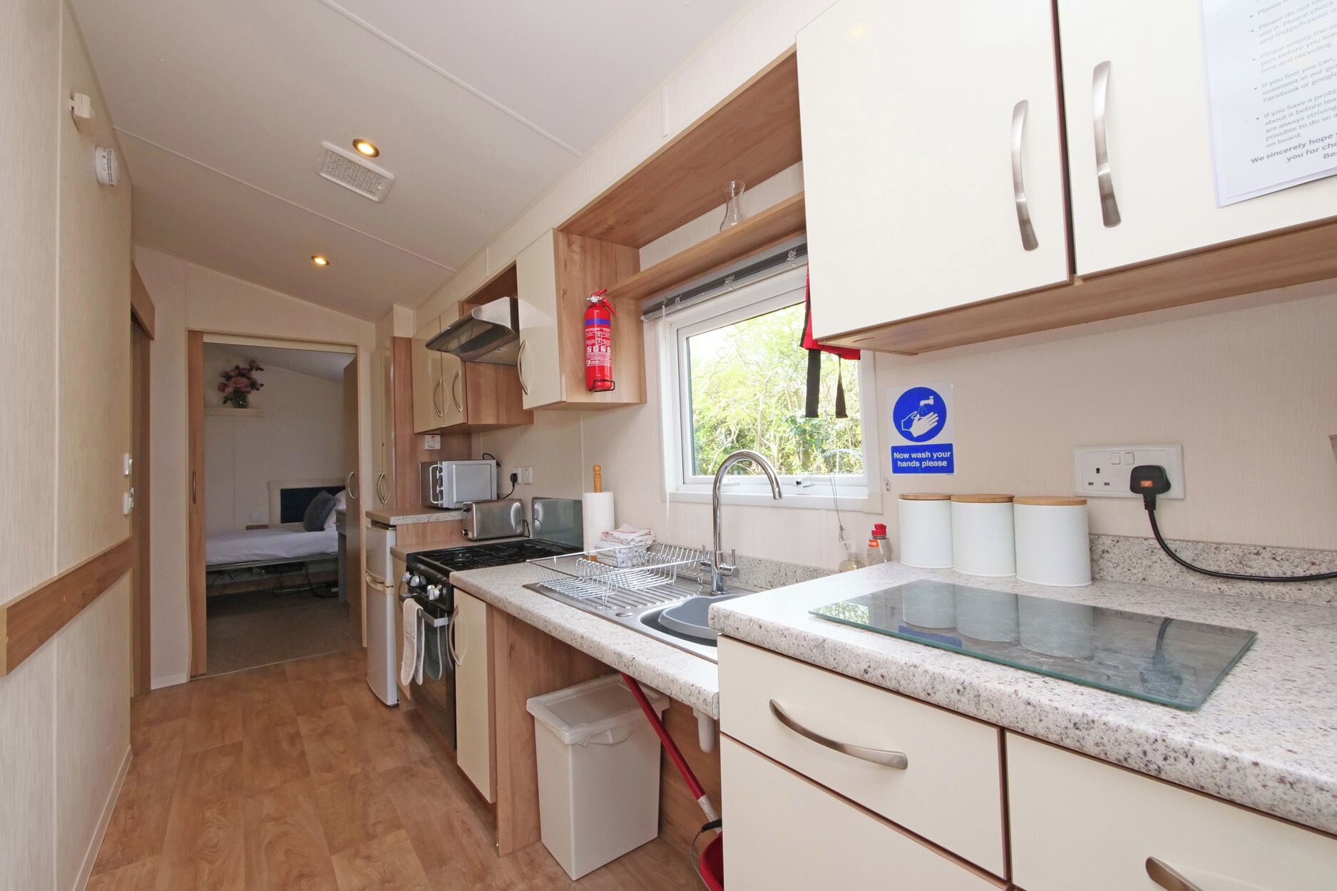 A compact kitchen with a stove, sink, and a window.