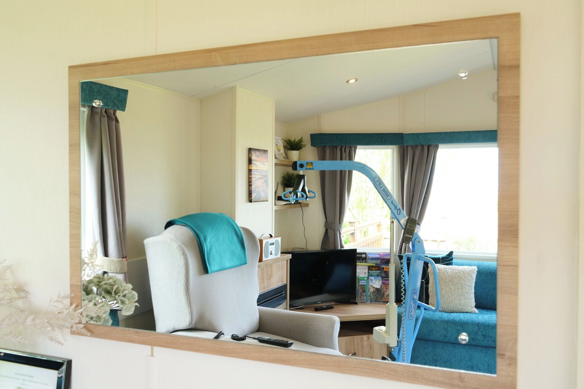 Une chambre avec un lit, une télévision, un bureau avec un ordinateur, une chaise et une fenêtre avec des rideaux.