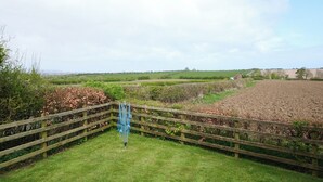 A rural landscape with a wooden fence, a grassy area, and fields in the background. - Abbey View @ Summerfield Farm (Whitby)