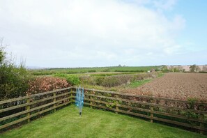 A rural landscape with a wooden fence, a grassy area, and fields in the background. - Abbey View @ Summerfield Farm (Whitby)
