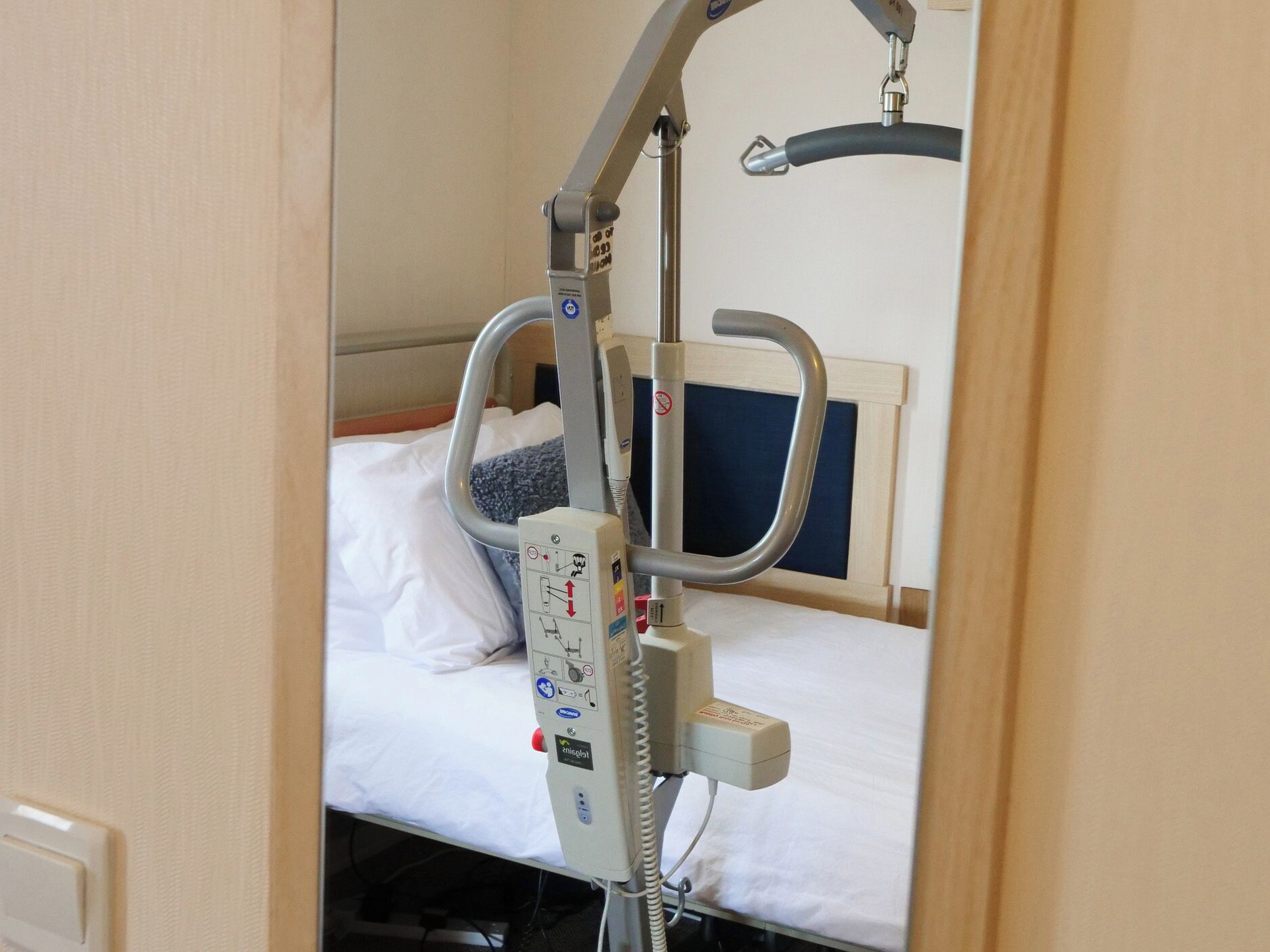 A hospital room with a bed, a medical bed, and a control panel.