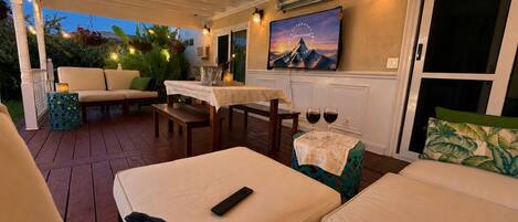 A cozy outdoor seating area with a table, chairs, and a sofa.