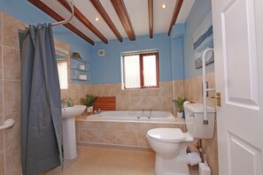 A bathroom with a bathtub, toilet, sink, and shower curtain. - Chomley @ Summerfield Farm (Whitby)