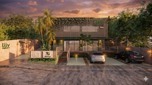 A modern building with a green facade, a covered entrance, and a car parked in front. - Liiv Nature Pipa (Tibau do Sul)