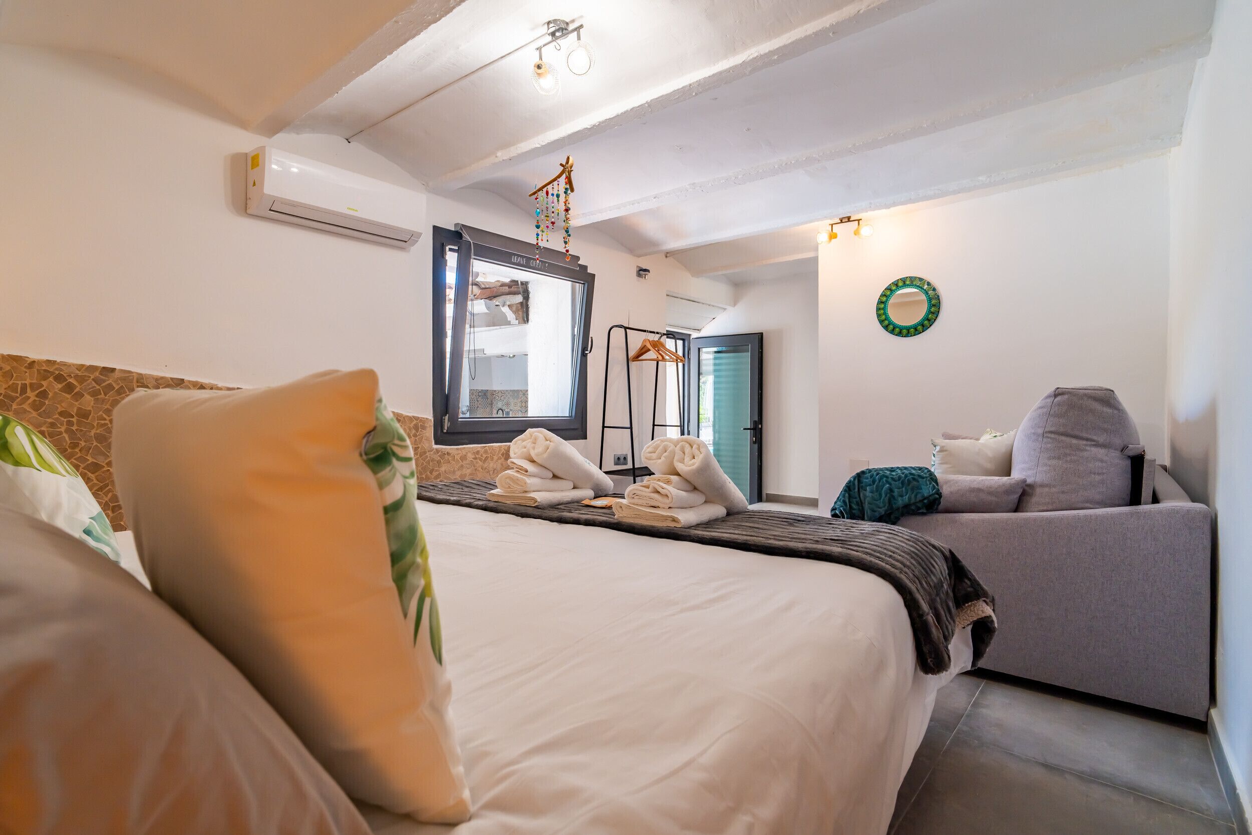 Ein Hotelzimmer mit Bett, Sofa, Kleiderschrank und Klimaanlage.