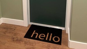 A door with a number '101' above it, a doormat with 'hello' on it, and a green door. - #101- Spacious 2-bedroom apartment in La Grande. (La Grande)