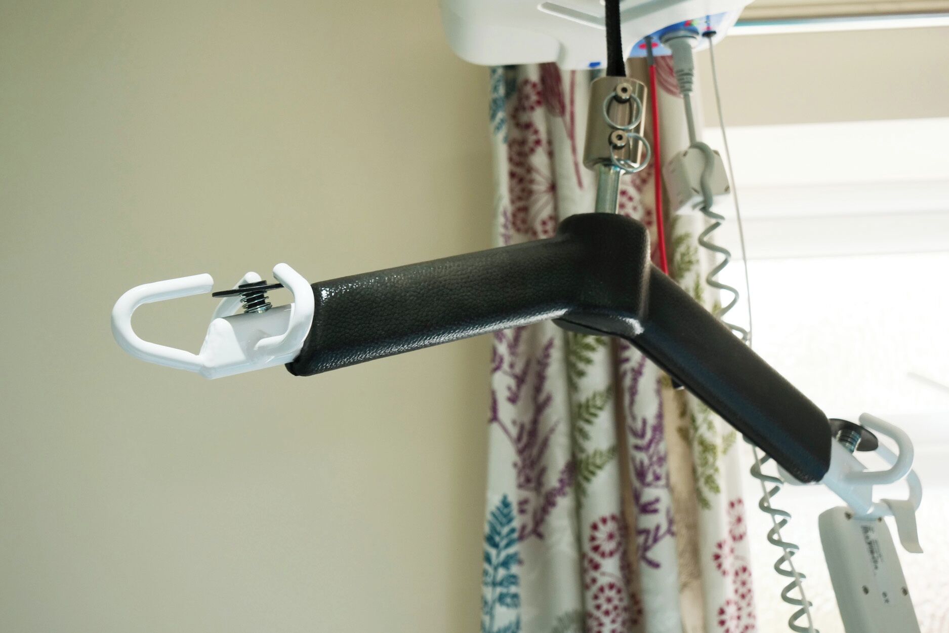 A black metal chair with a white plastic handle and a spring mechanism.