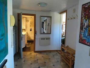 Ein Flur mit einer zur Küche führenden Tür, einem Heizkörper und einem Bild an der Wand.