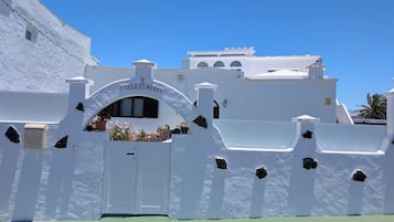 Un edificio bianco con un cartello che recita 'Calle El Morro' e un ingresso con cancello.