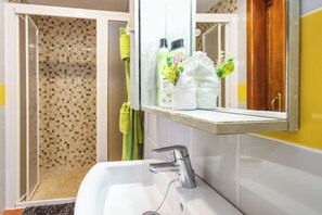 A bathroom with a shower, a sink, and a mirror. - Finca Villanueva (Mala)