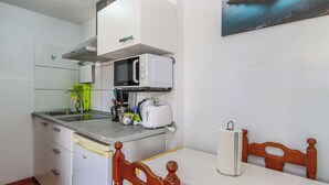 A compact kitchen with a microwave, toaster, and sink.