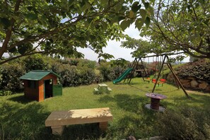 A playground with a slide, swings, and a small wooden structure. - Air-conditioned gîte with swimming pool and garden in the countryside, ideal for families (Pertuis)