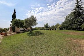 A grassy area with trees and a building. - Air-conditioned gîte with swimming pool and garden in the countryside, ideal for families (Pertuis)