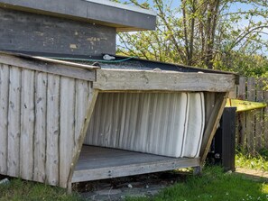 A wooden structure with a slanted roof, a concrete base, and a metal gutter. - 5 Star Holiday Home in Koge (Koge)