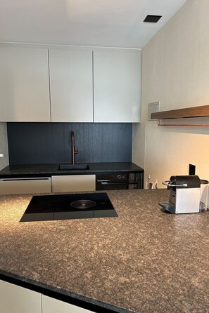 Eine moderne Küche mit Granit Arbeitsplatte, Edelstahlgeräten und weißen Schränken.