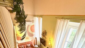 Ein gemütliches Wohnzimmer mit einer Couch, einem Esstisch und einer Treppe.